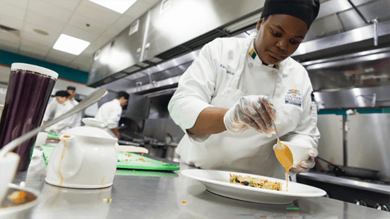 A culinary arts student at Grand Rapids Community College (Michigan) sharpens her food-preparation skills. (Photo: Grand Rapids Community College)