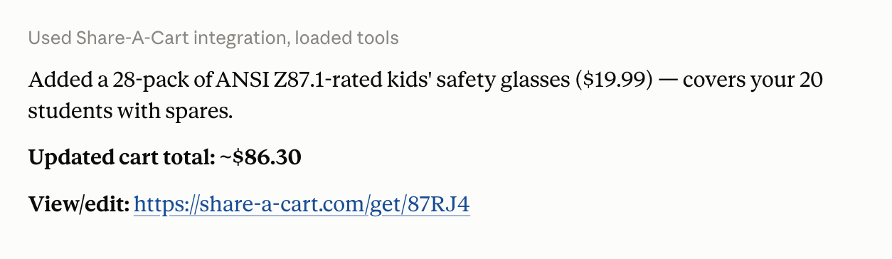 Claude confirming a 28-pack of kids safety glasses was added to the cart, with the updated cart total and the cart link